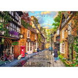 Ravensburger adult puzzle featuring Meadow Hill Lane scene with charming houses and lush greenery, assembled on a wooden table.